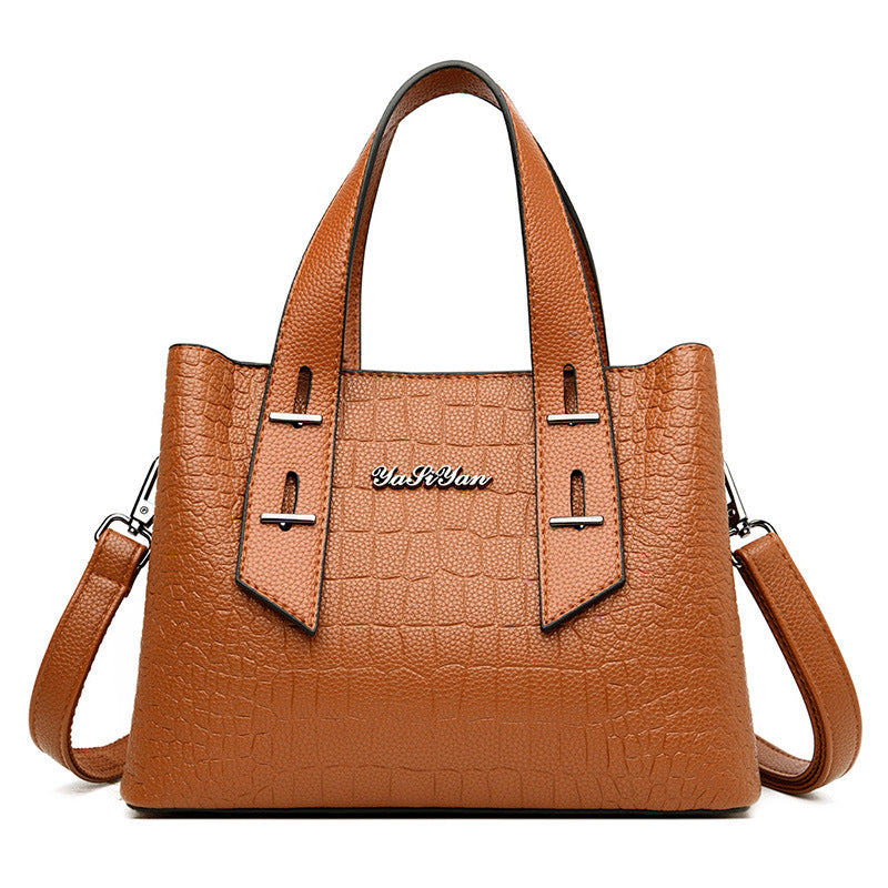 Brown handbag with a visible brand logo on a white background