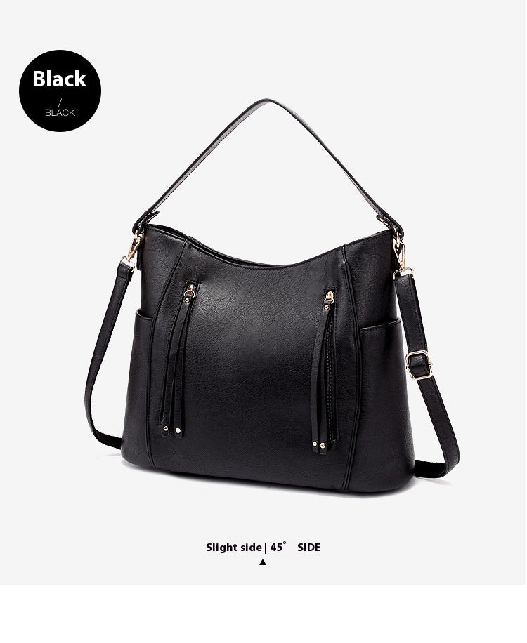 Black handbag with gold accents on a light gray background