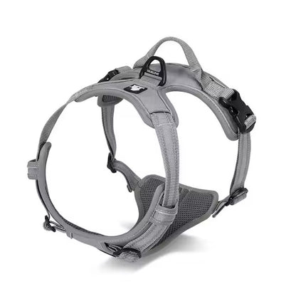 Grey adjustable dog harness with reflective straps, padded chest panel, top control handle, and rear leash attachment ring.